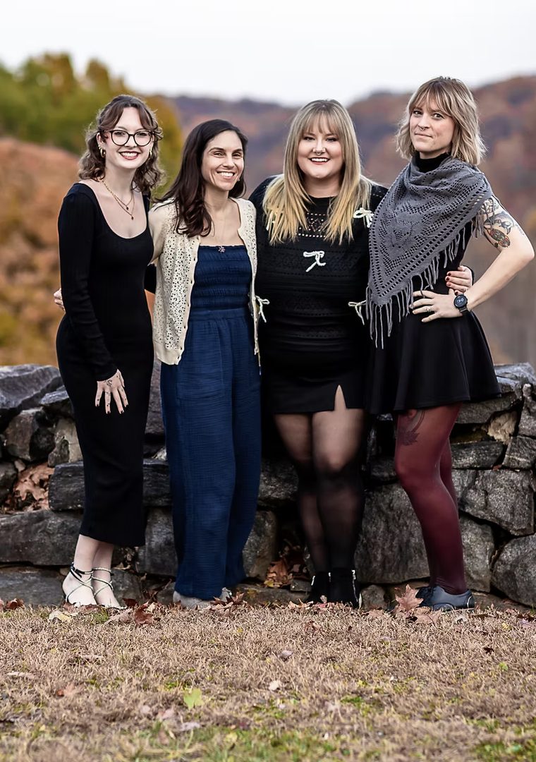 Catherine, Christina, Katelin, and Christine standing together on an autumn hillside